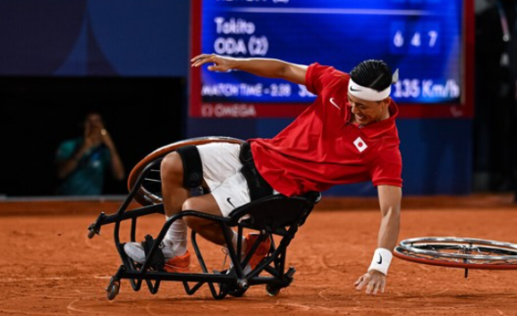 A guy in a wheelchair playing tennis